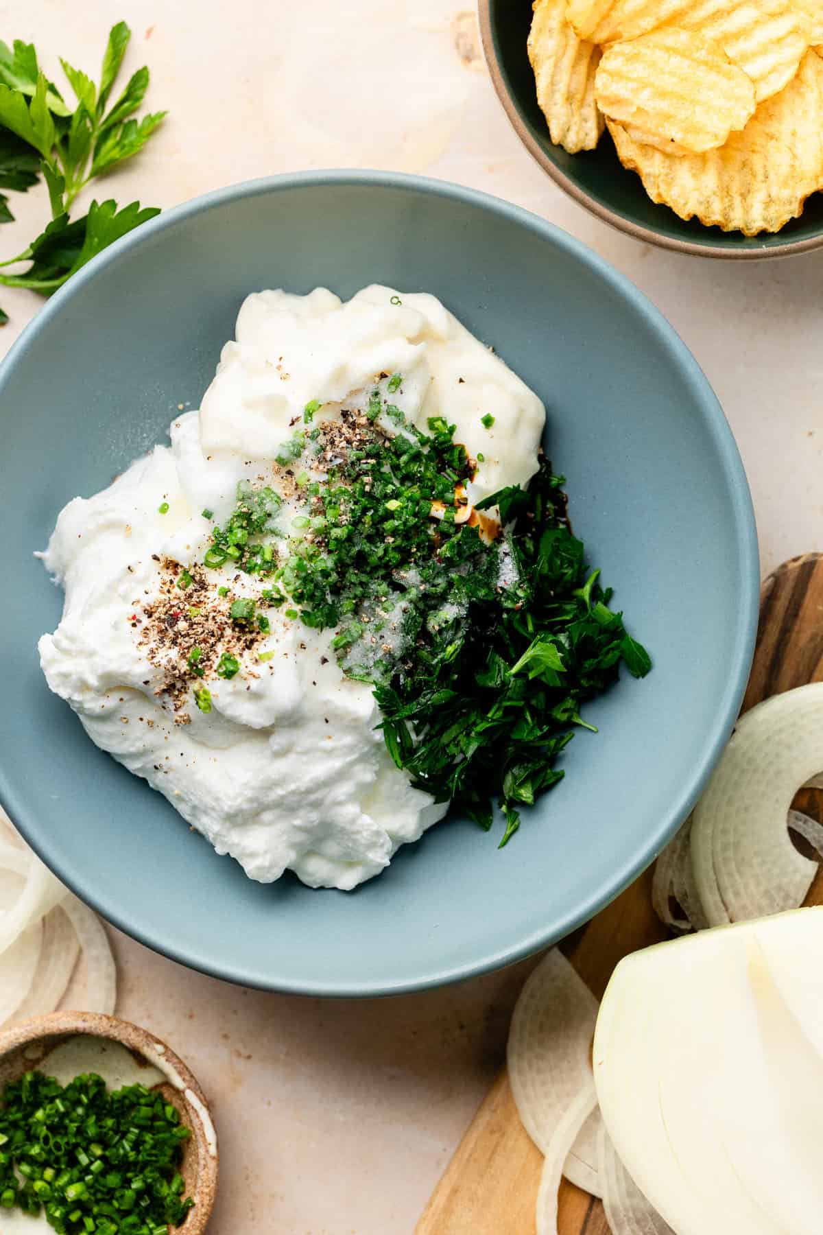 Greek yogurt, mayo, and herbs in mixing bowl