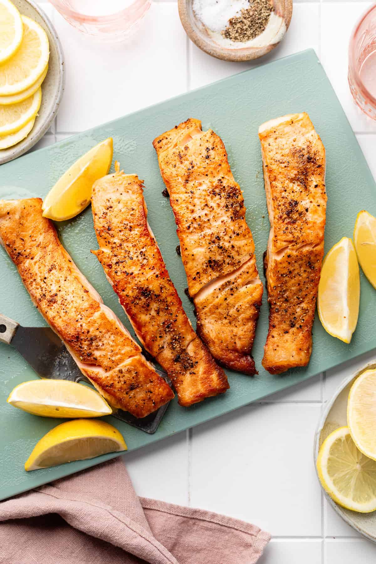 salmon on serving board with lemon wedges