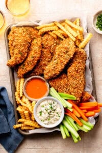 chicken tenders, fries, blue cheese, veggies, and buffalo sauce on sheet pan lined with parchment