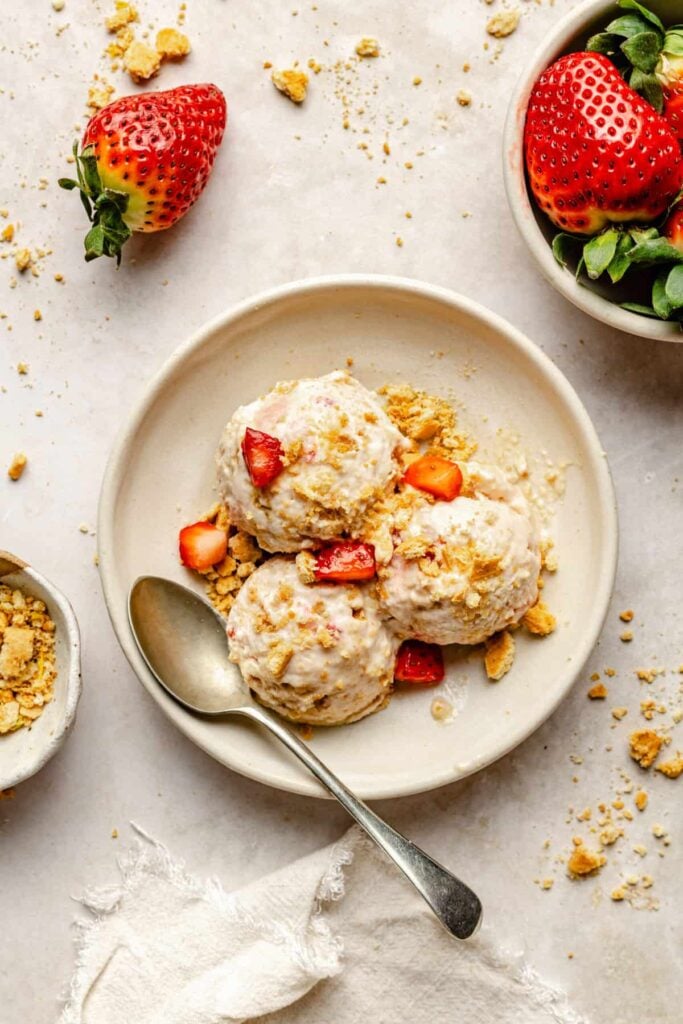 strawberry cheesecake cottage cheese ice cream scooped in bowl with spoon