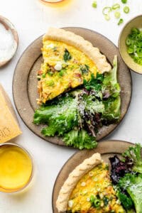 spinach bacon quiche on plate with mixed greens