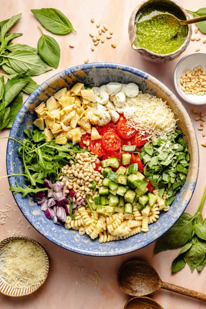pesto pasta salad ingredients in mixing bowl