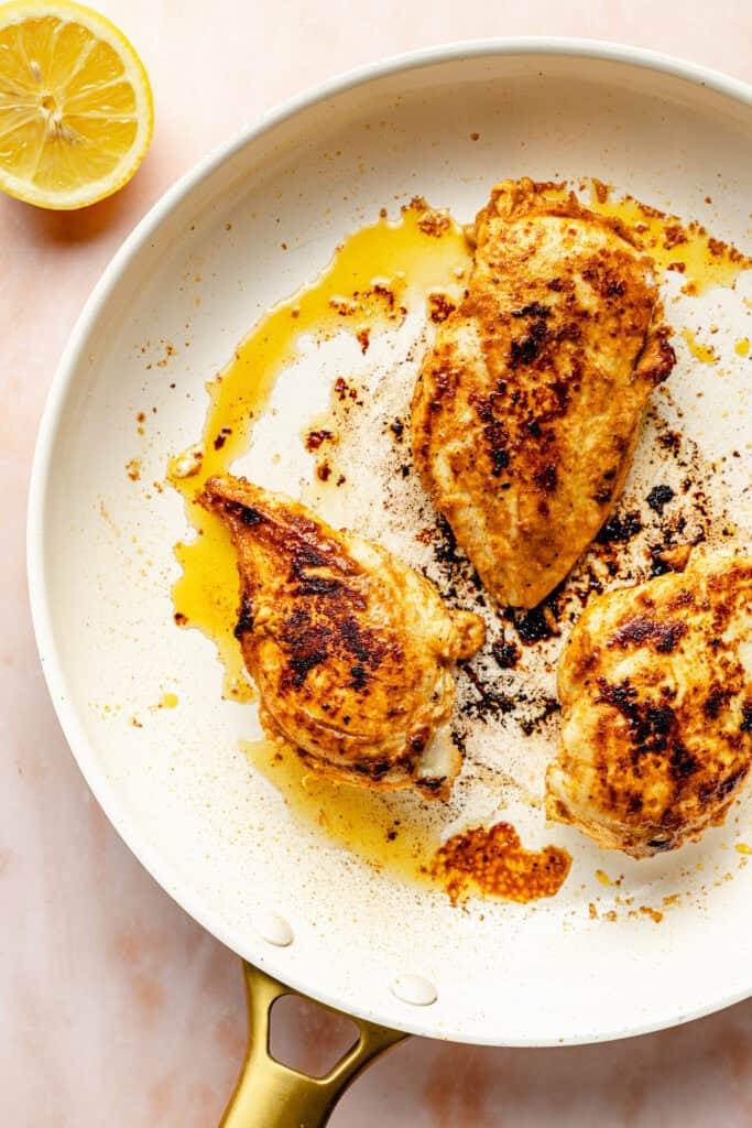 seasoned chicken breast cooking in skillet 