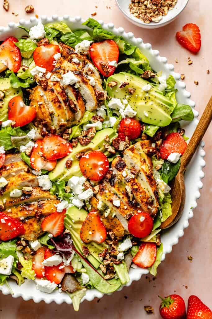 salad with serving spoon in white bowl