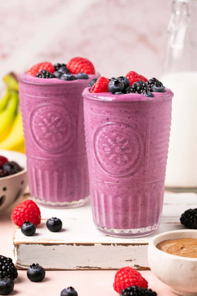 smoothies in glasses topped with berries