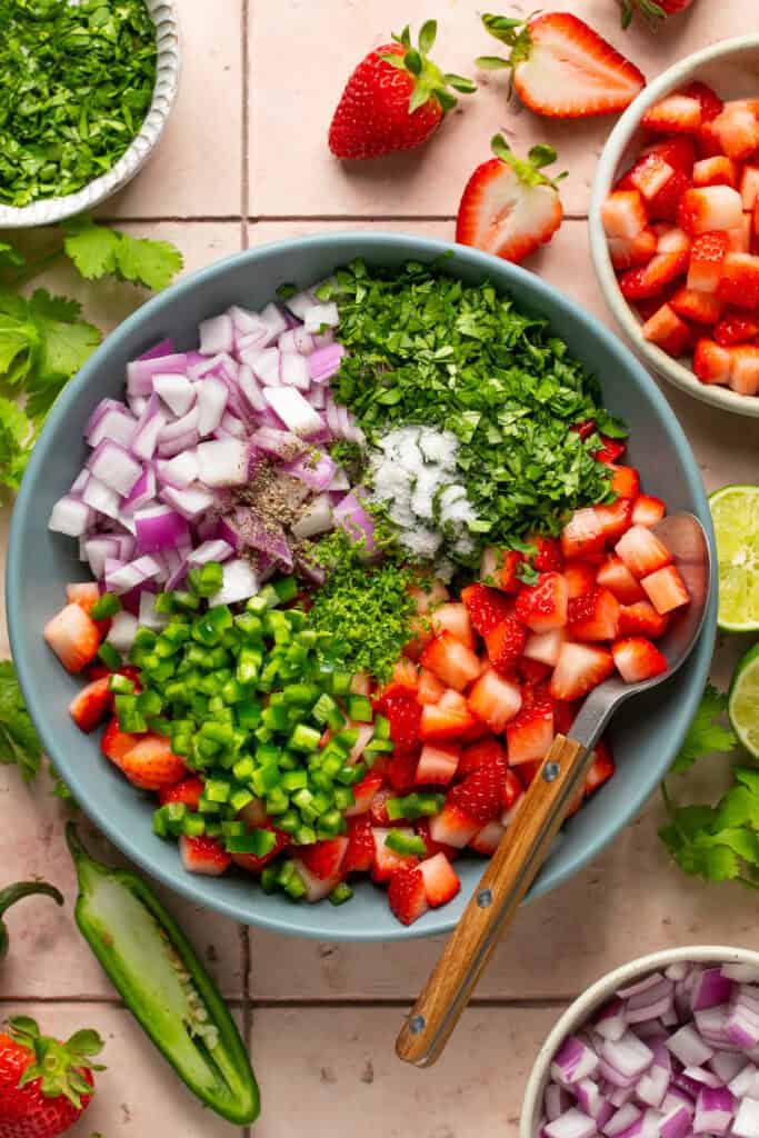 salsa ingredients chopped in bowl with spoon