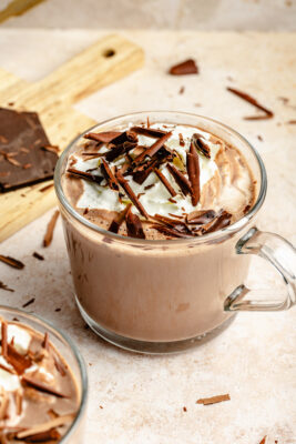 hot chocolate in mug topped with whipped cream and chocolate shavings