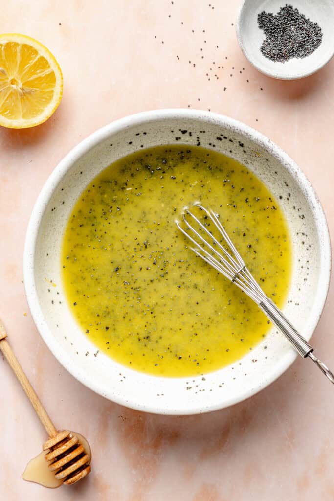 poppy seed dressing in small bowl with whisk