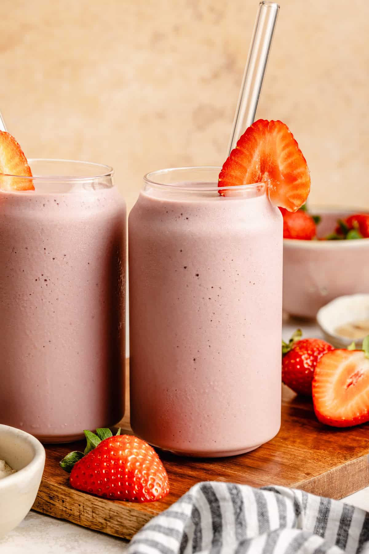 strawberry protein shake in glass topped with strawberry