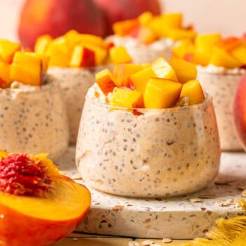 peach overnight oats in serving cup on cutting board