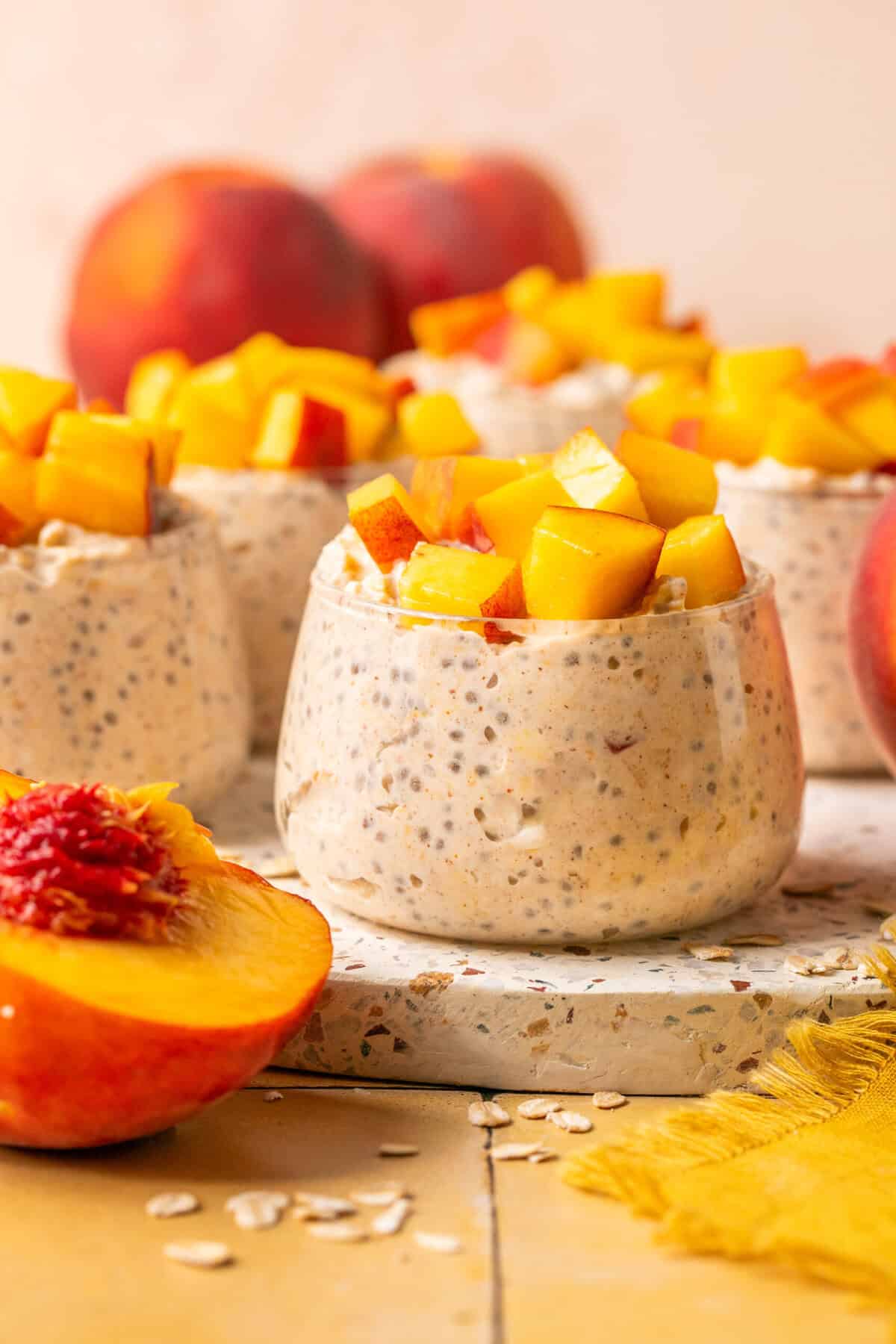 peach overnight oats in serving cup on cutting board