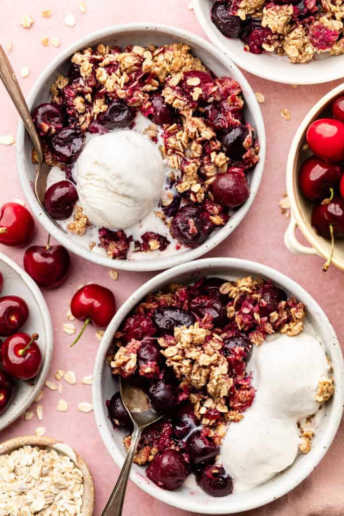cherry crisp in bowls with spoons