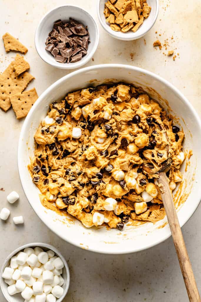 mix ins folded into batter in bowl with wooden spoon