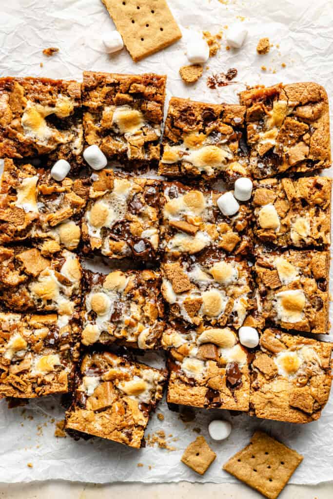 s'mores bars sliced into bars on parchment paper