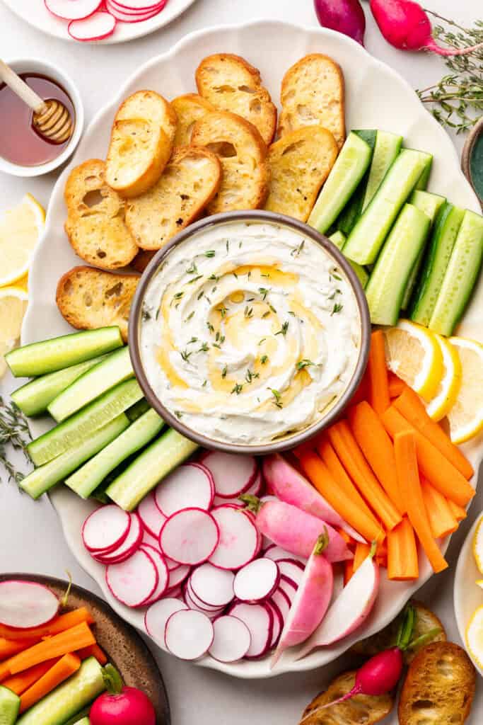 whipped goat cheese in bowl with veggies and bread 