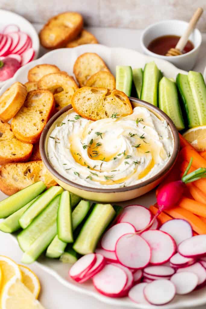 whipped goat cheese in bowl with veggies and bread