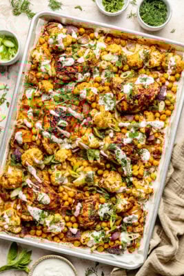 chicken and veggies on sheet pan drizzled with tahini sauce