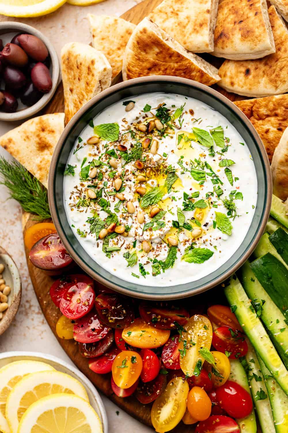 labneh dip with toppings served with veggies and pita