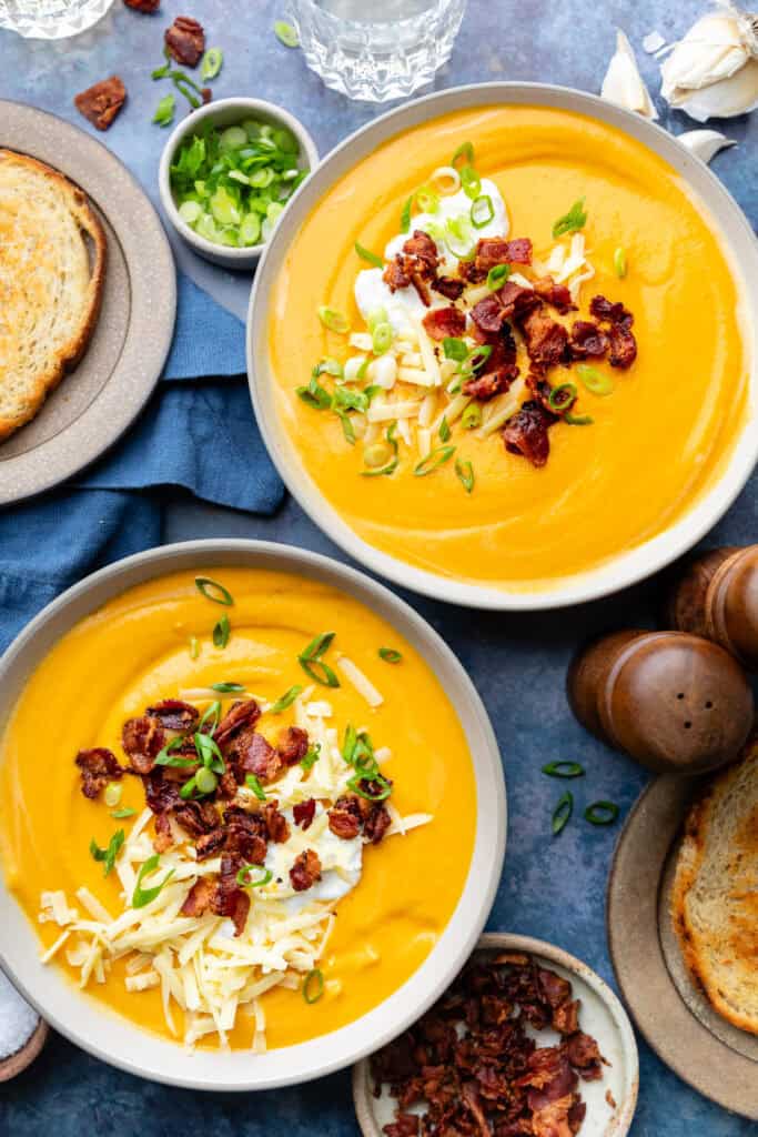 sweet potato soup in two bowls with toppings