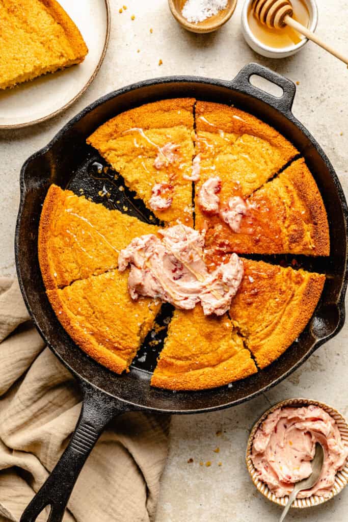 cornbread in skillet with honey butter