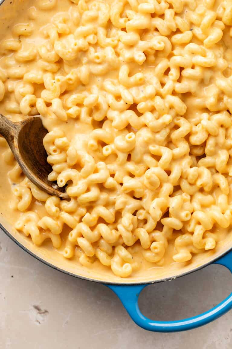 Mac and cheese in dutch oven with wooden spoon