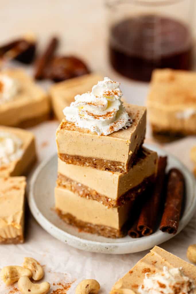 sweet potato cheesecake bars stacked on each other with whipped cream