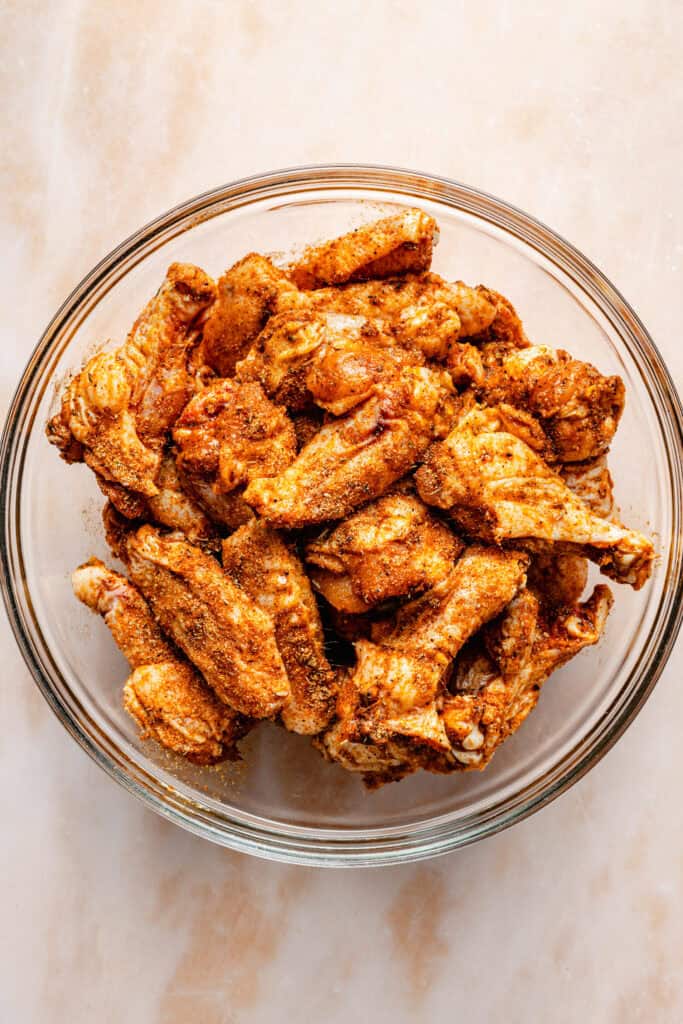 wings with dry rub in mixing bowl