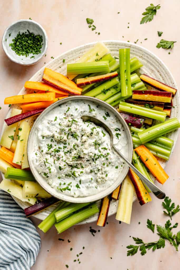 dressing in bowl with herbs and veggies