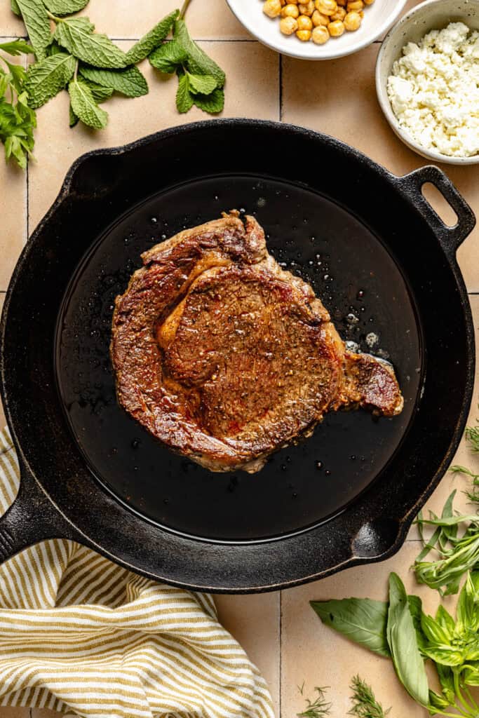 steak being seared in cast iron skillet