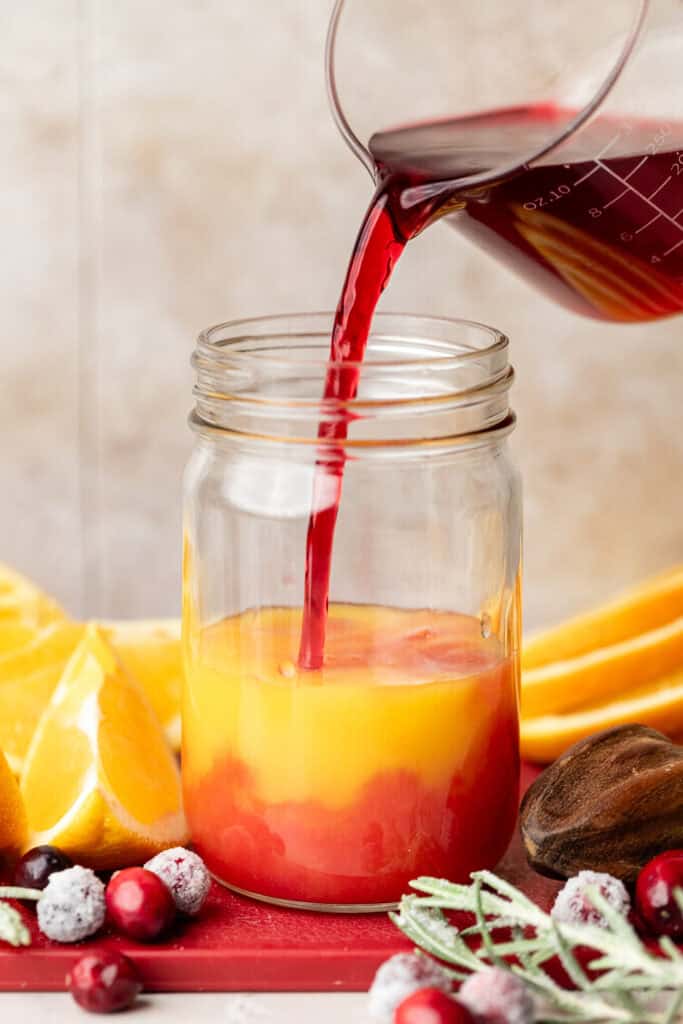 cranberry juice being poured into orange juice