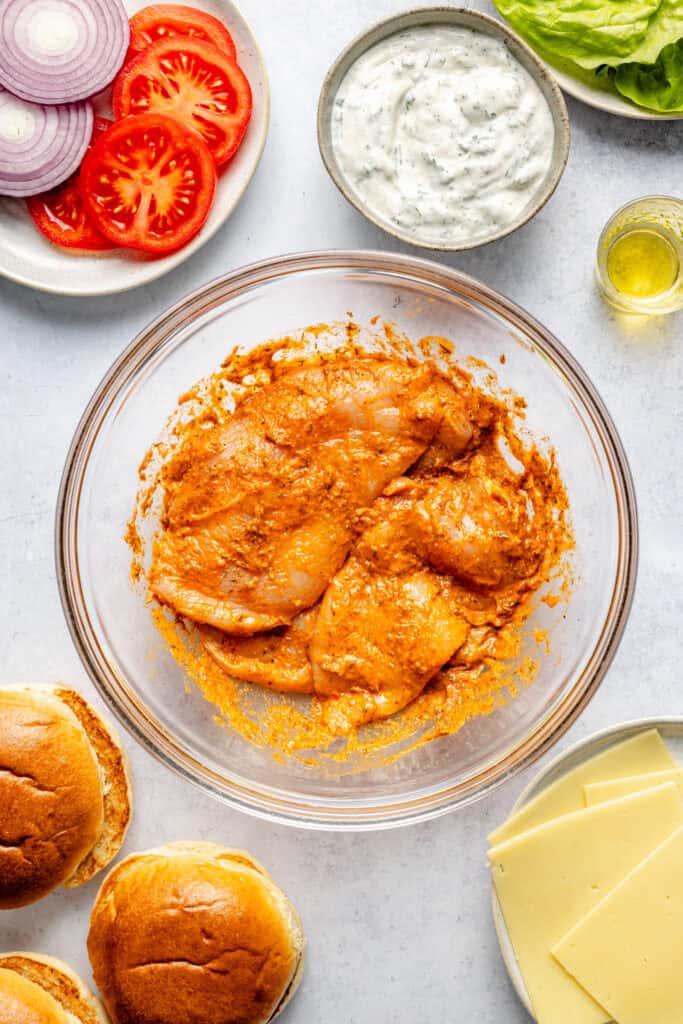 chicken breast marinating in mixing bowl