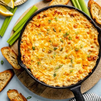 crab dip in skillet with veggies and crostini