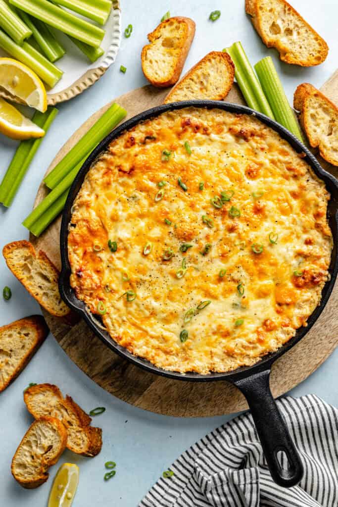 crab dip in skillet with veggies and crostini