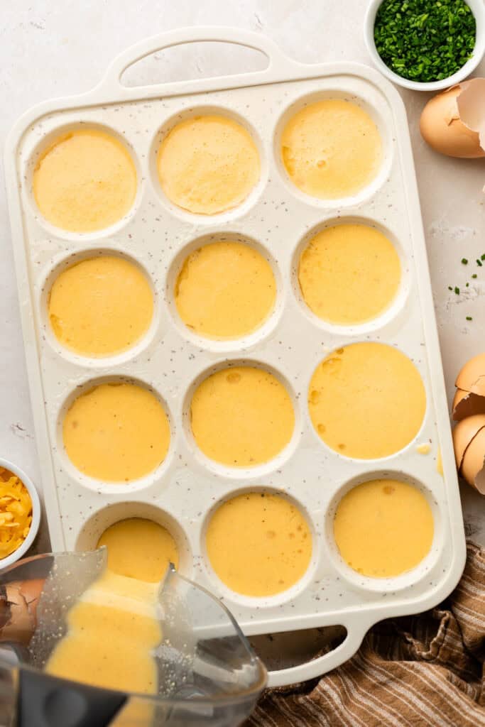 eggs being poured into muffin tin