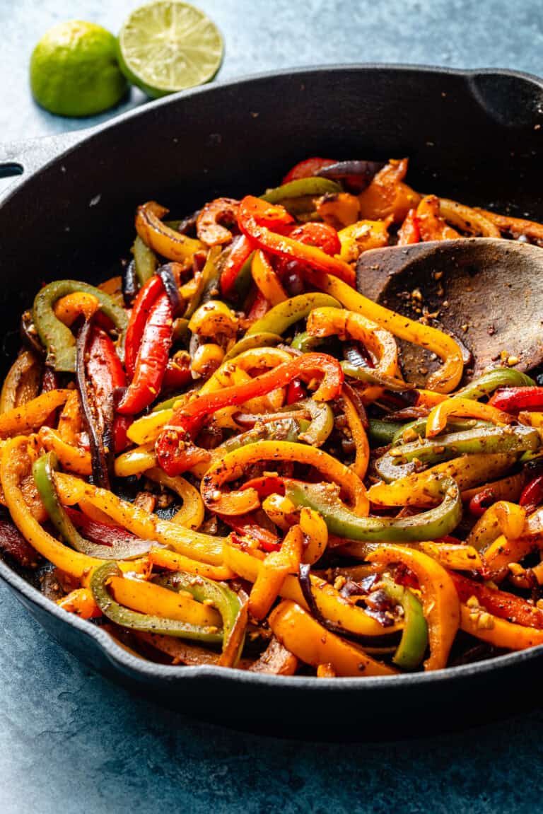veggies in skillet with wooden spoon