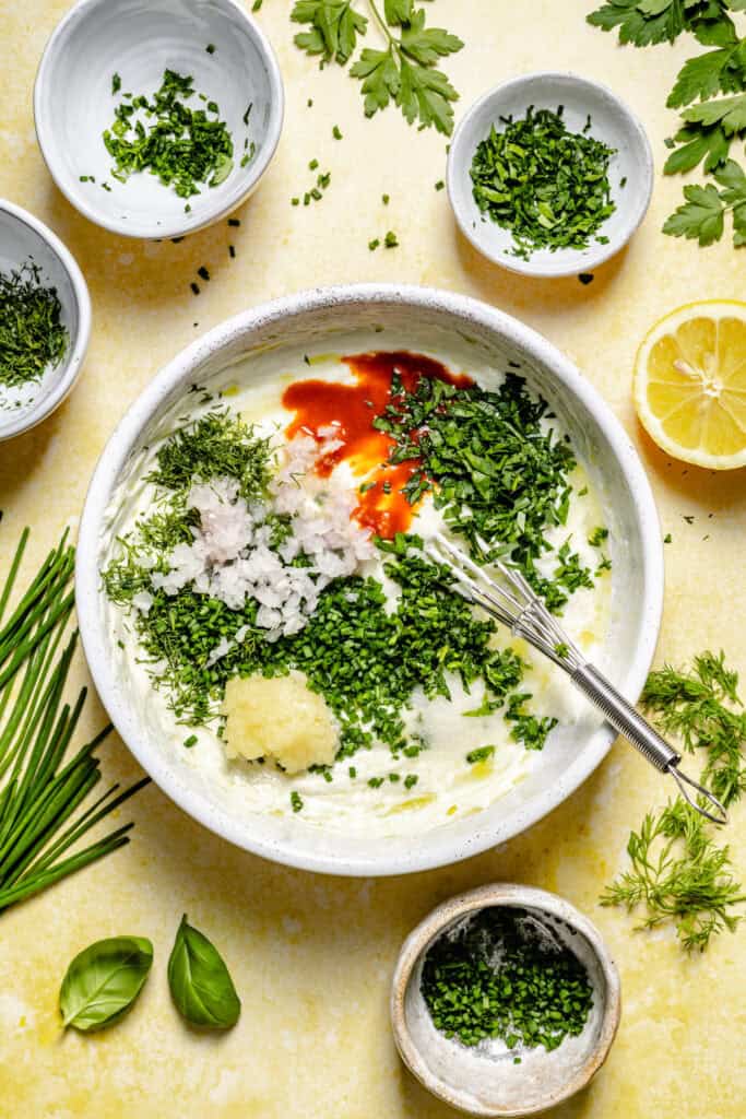 dressing ingredients in bowl with whisk