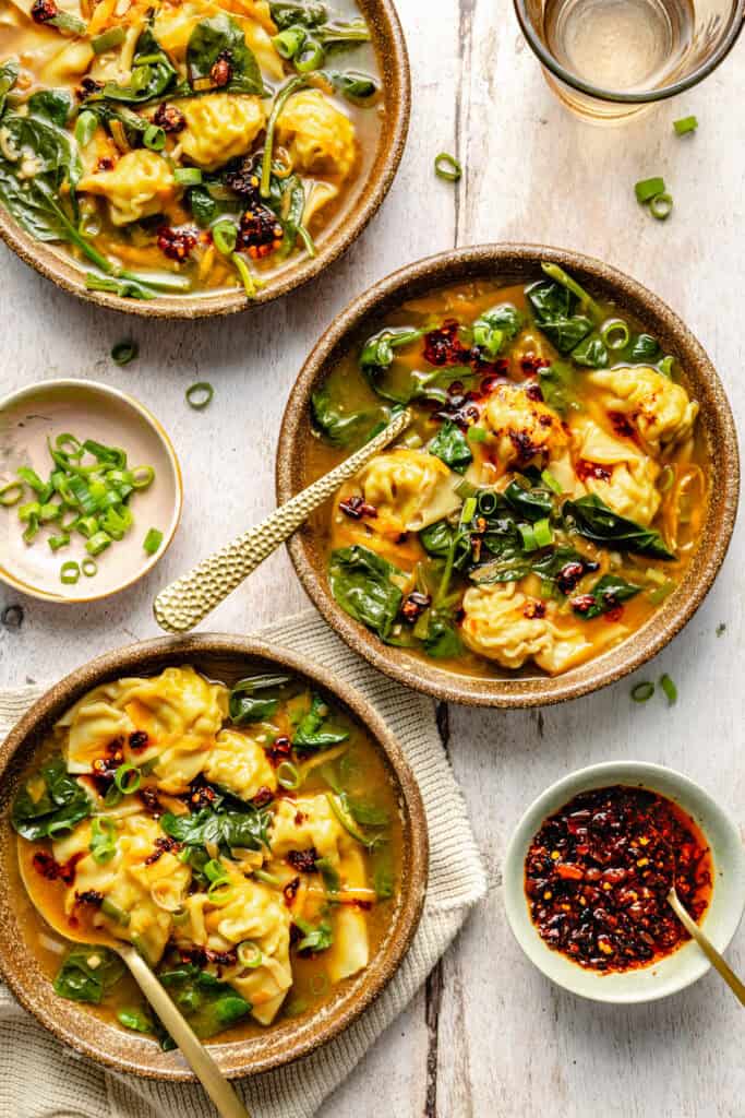 wonton soup in two bowls with spoon