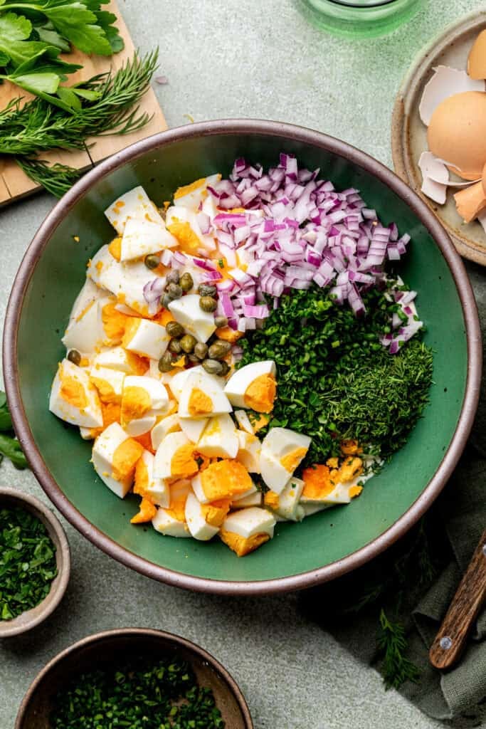 egg salad ingredients in mixing bowl