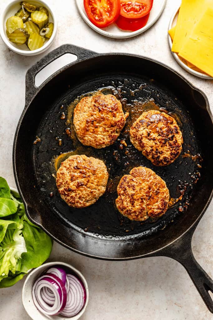 turkey burgers cooking in skillet
