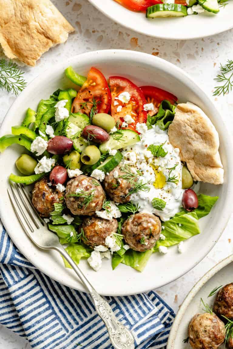 greek meatballs in bowl with veggies and tzatziki