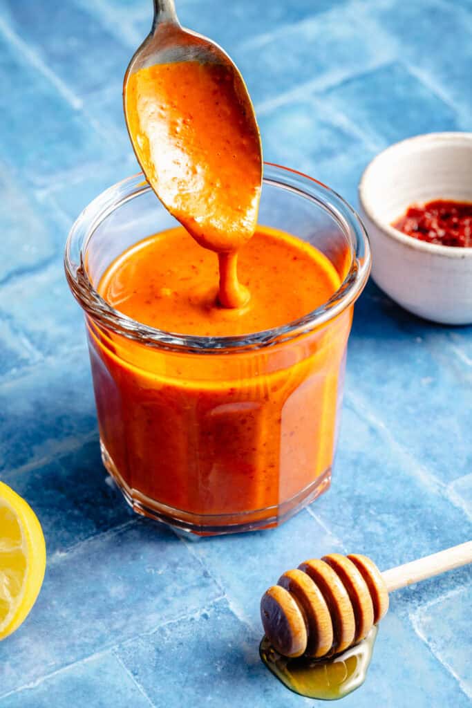 harissa dressing in mason jar with spoon