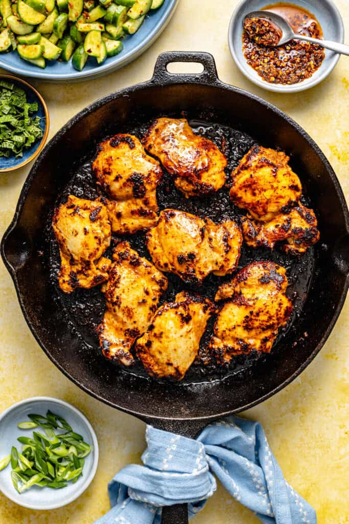 red curry chicken thighs being cooked in skillet