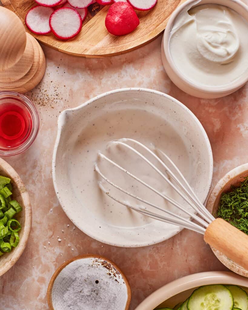 dressing ingredients being whisked in bowl