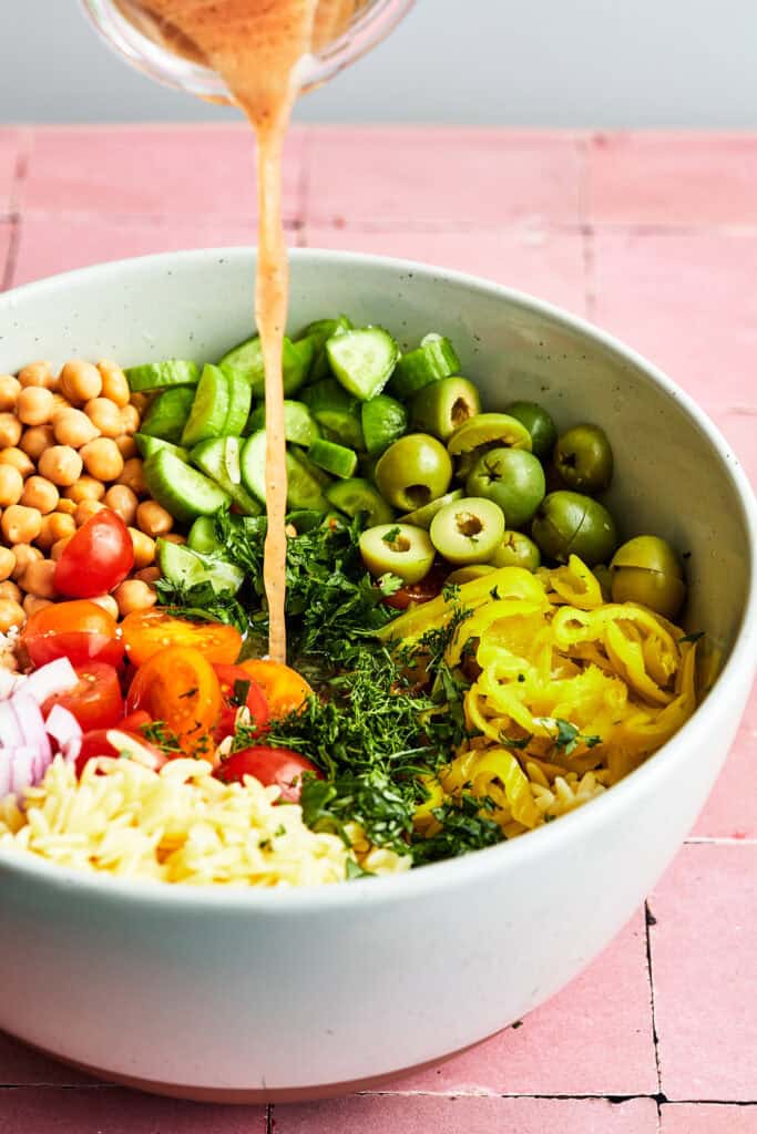 dressing being poured over salad