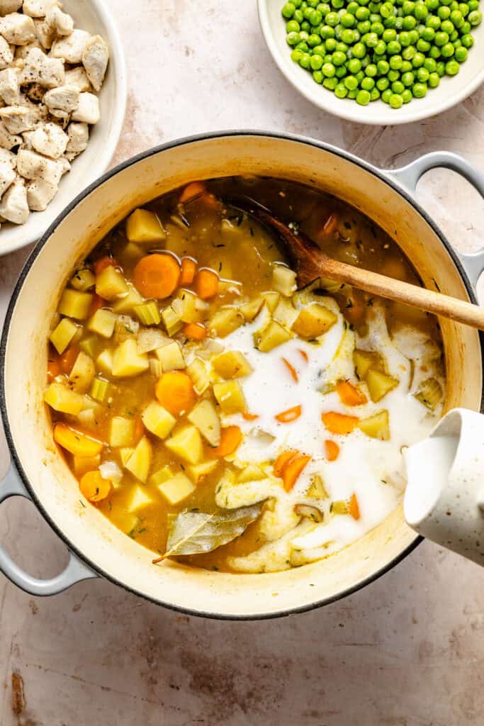 coconut milk being poured into soup