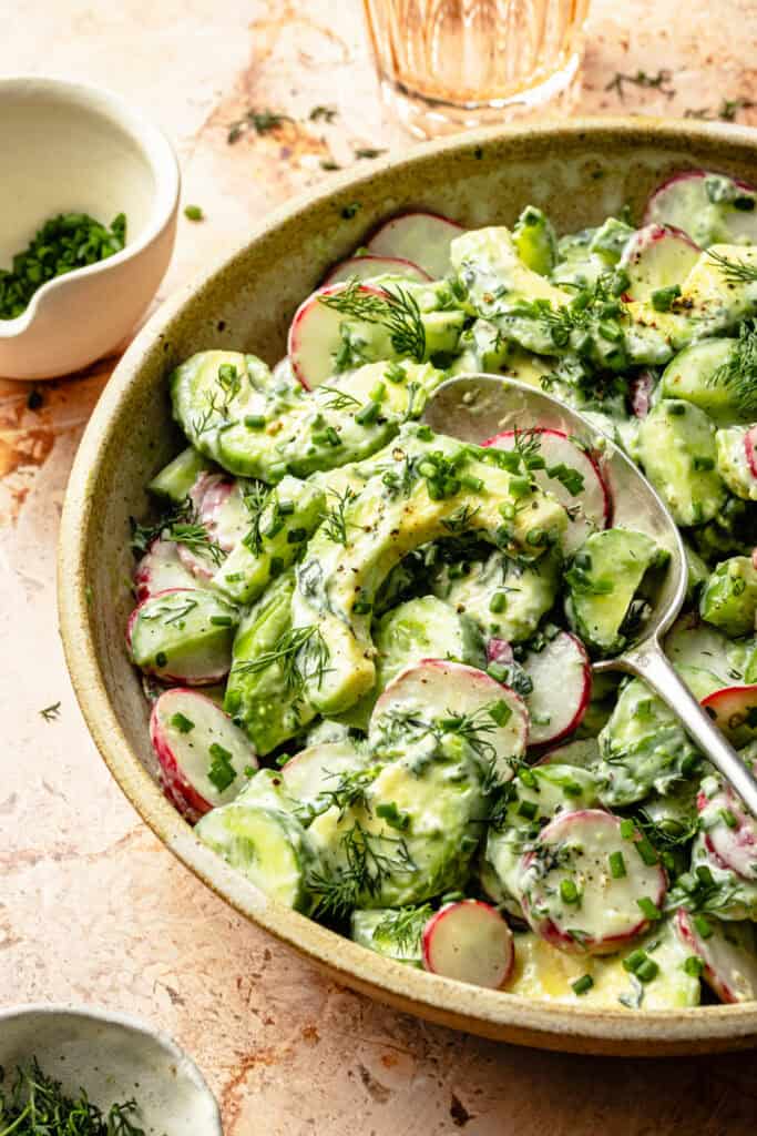 buttermilk avocado cumber salad in bowl with spoon