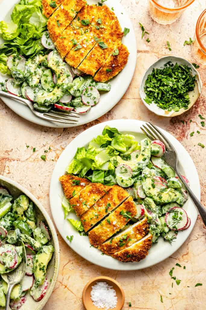 crispy chicken cutlet on plate with cucumber salad