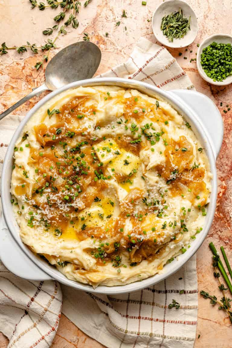 caramelized onion mashed potatoes in serving dish topped with butter