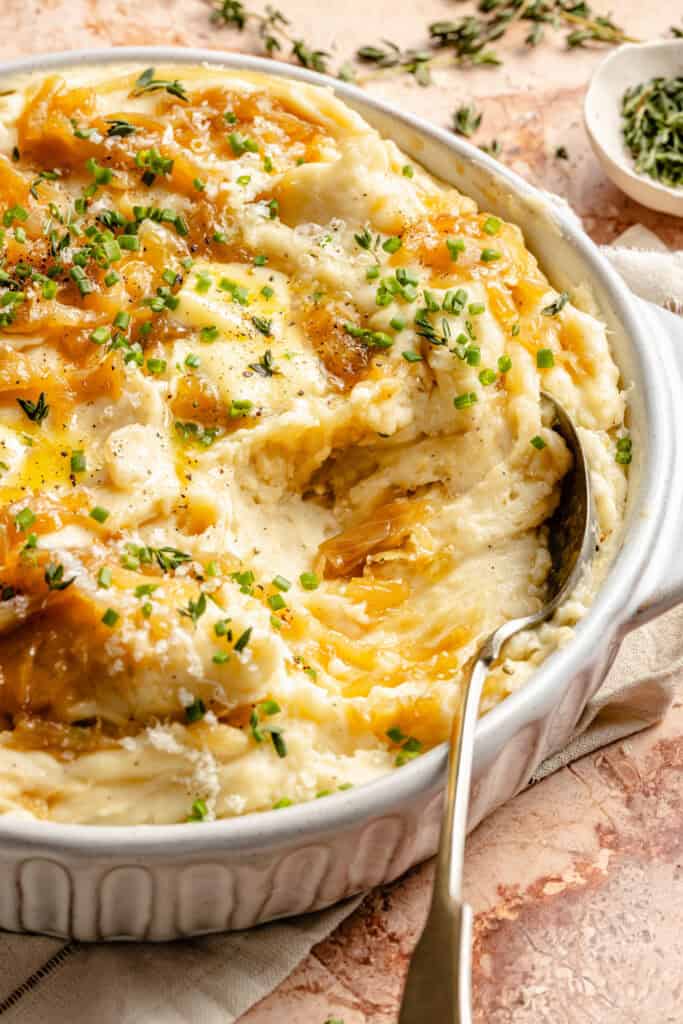 caramelized onion mashed potatoes in serving dish with spoon