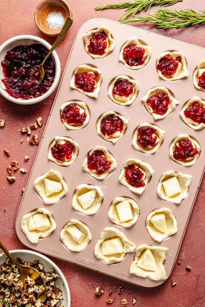 adding cranberry sauce to brie bites